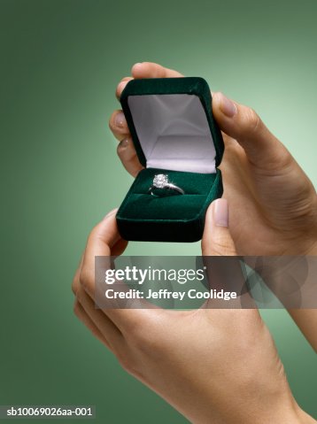 Woman's hands holding diamond ring in box, close-up Woman's hands holding diamond ring in box, close-up