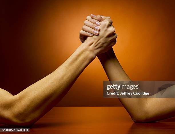 man and woman arm wrestling, studio shot - echar un pulso fotografías e imágenes de stock