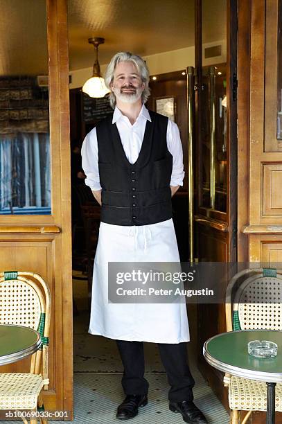france, paris, portrait of waiter standing in cafe door - pride paris photos et images de collection