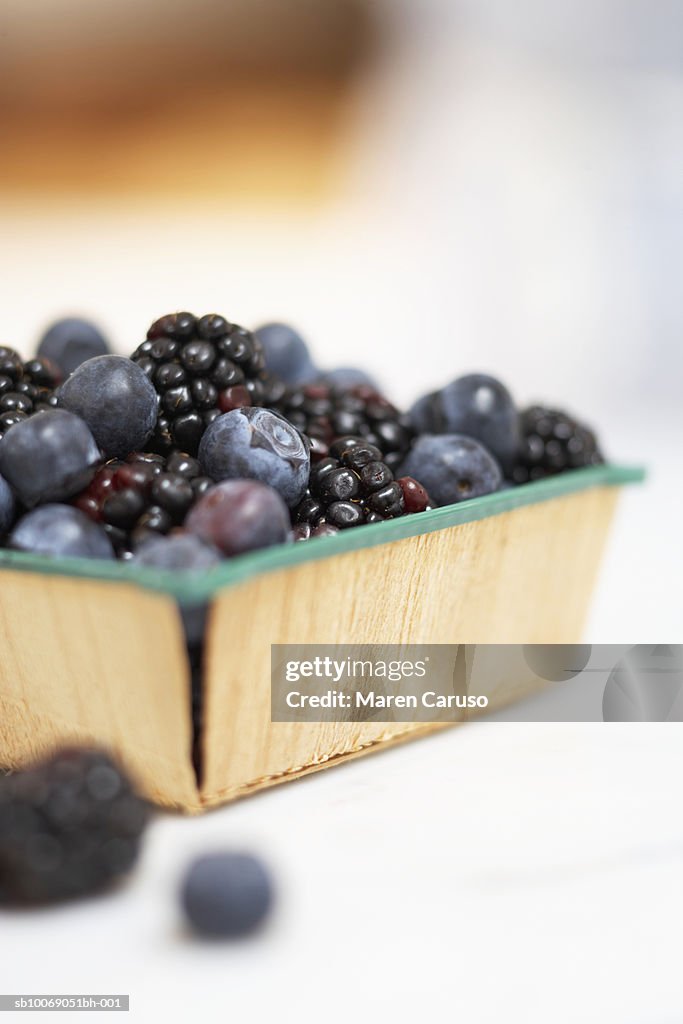 Fresh blueberries an blackberries in basket, close-up