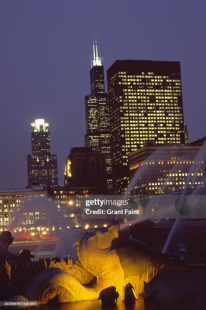 USA, Chicago, fountain with skyline illuminated at dusk