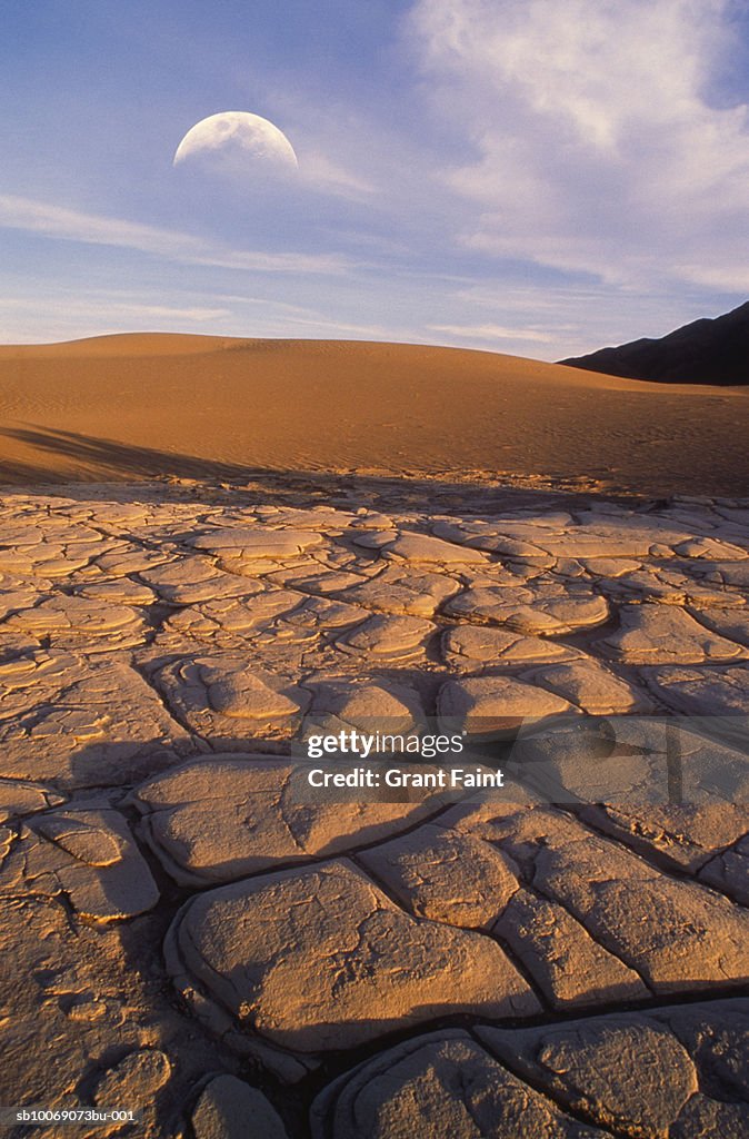 USA, California, Death Valley, cracked soil in desert with moon