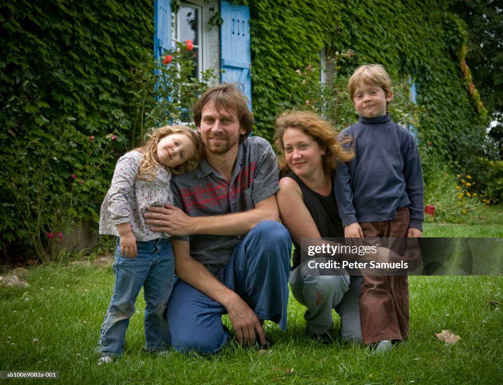 Portrait of family with two children (4-7) in front of house