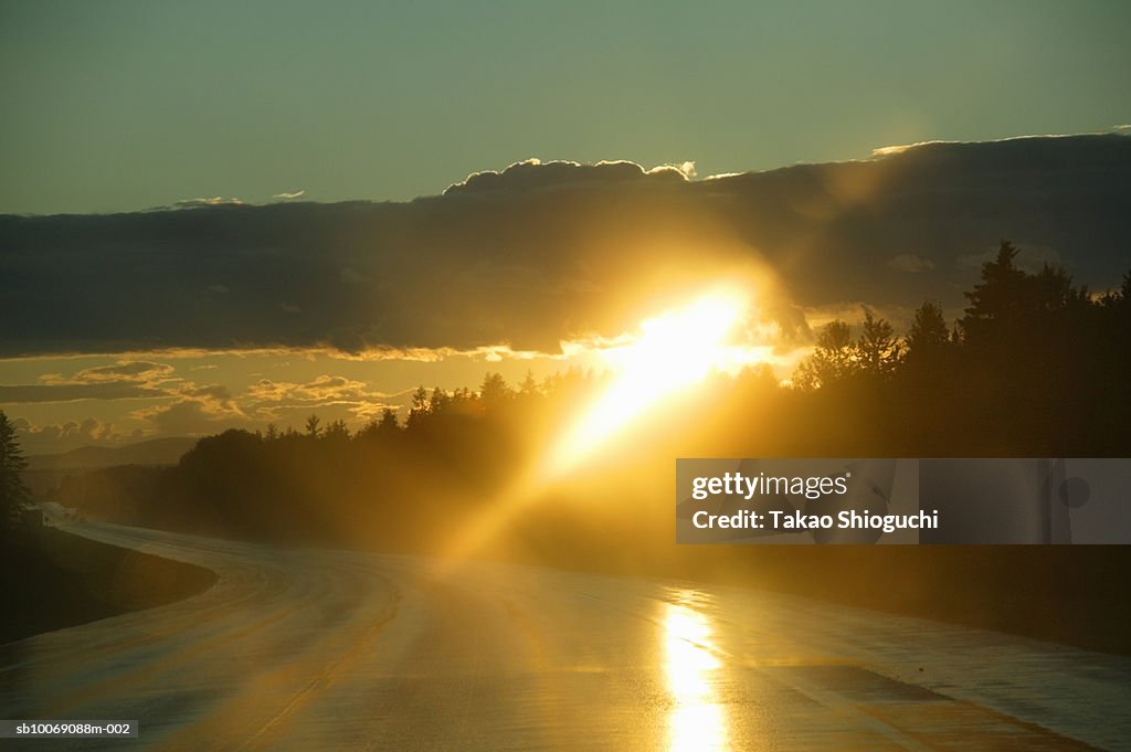 Canada, New Brunswick, Bathurst, Sunrays falling on road sunset