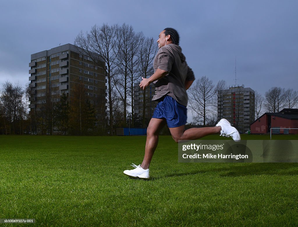 Man wearing headphones, jogging, side view