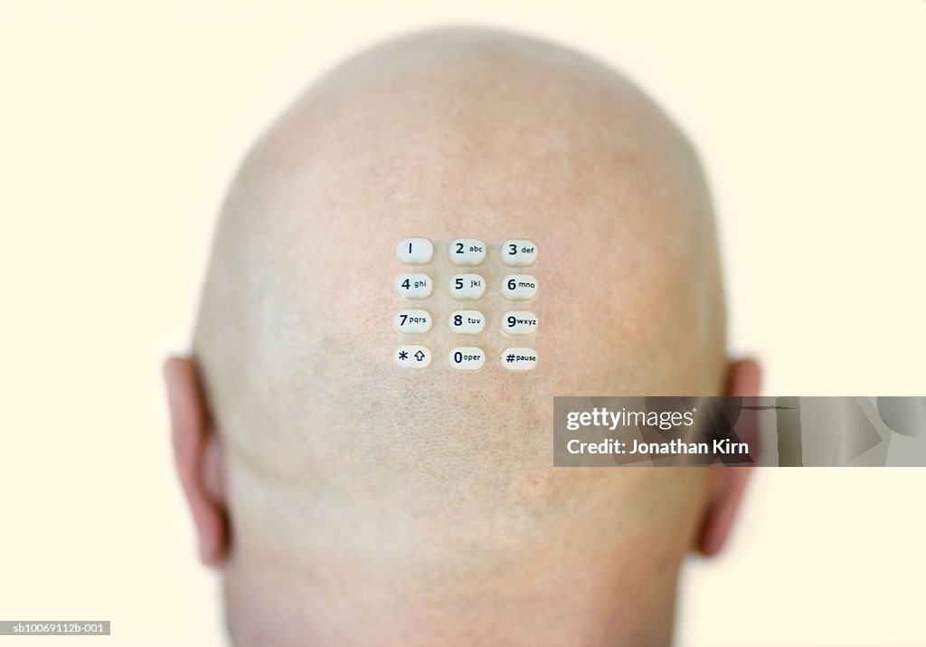 Bald man with keypad stuck on head