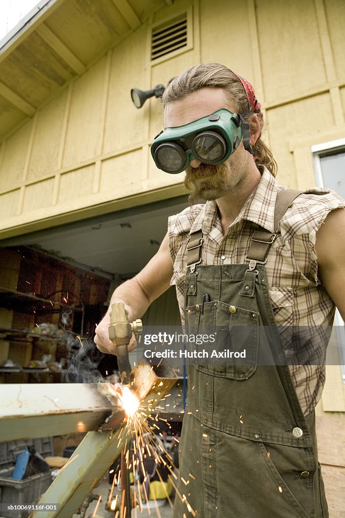 Young man welding metal