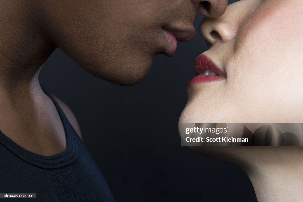 Man and woman about to kiss, close up of lips, studio shot