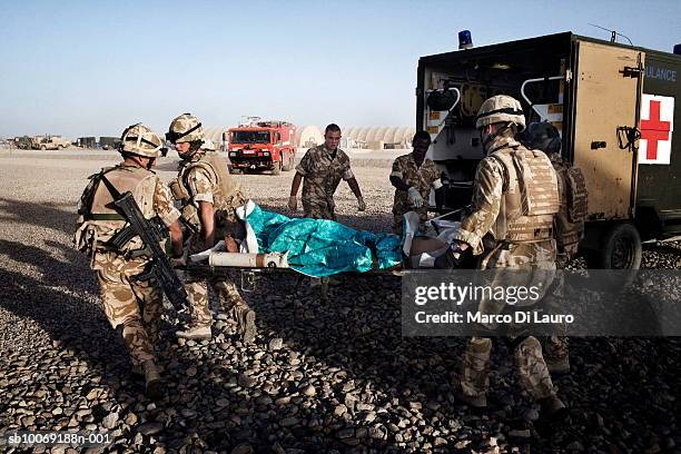 June 2007. British Army Medical Emergency Response team from the UK Med Group carry injured Afghan National Army Sgt. Quem Abdulh into an ambulance,...