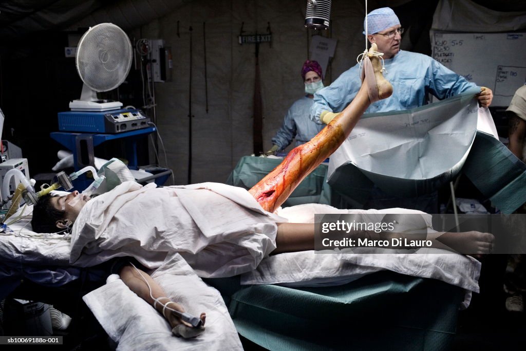 Doctors operating in military camp operating room