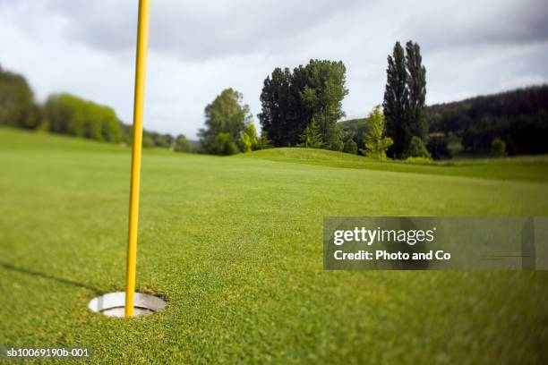 france, dordogne, golf hole with flag pole - golfplatz green stock-fotos und bilder