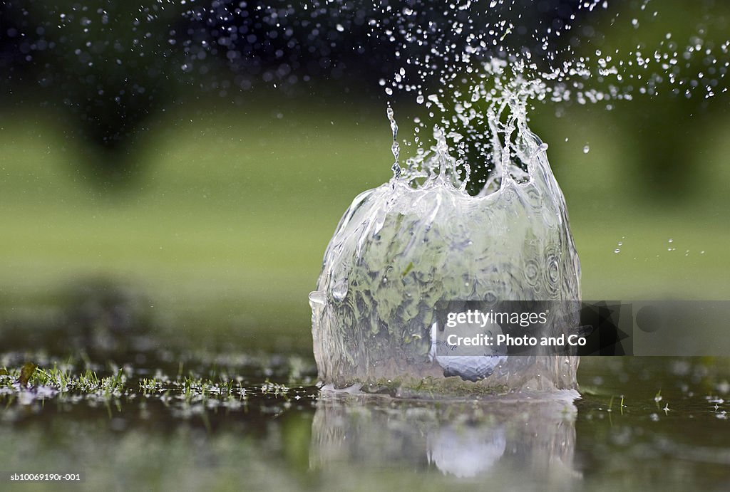Golf ball landing in pond, close-up