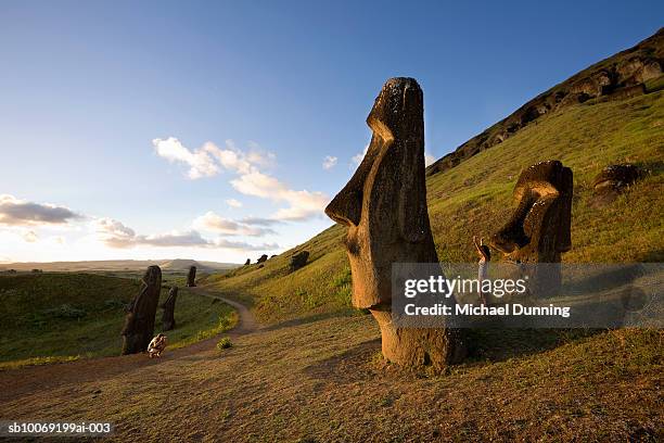 easter island, rano raraka, man photographing woman by ancient moai statues - ilha de páscoa imagens e fotografias de stock