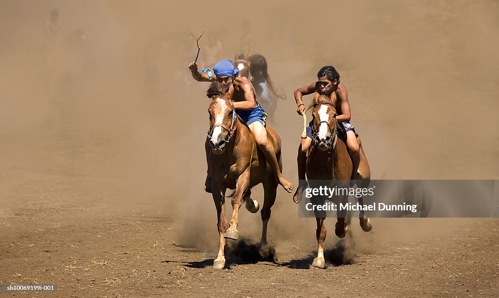 Two people racing on horses