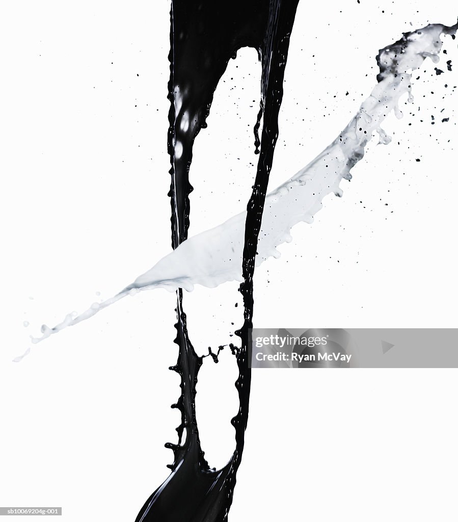 Black paint and white paint against white background, close-up