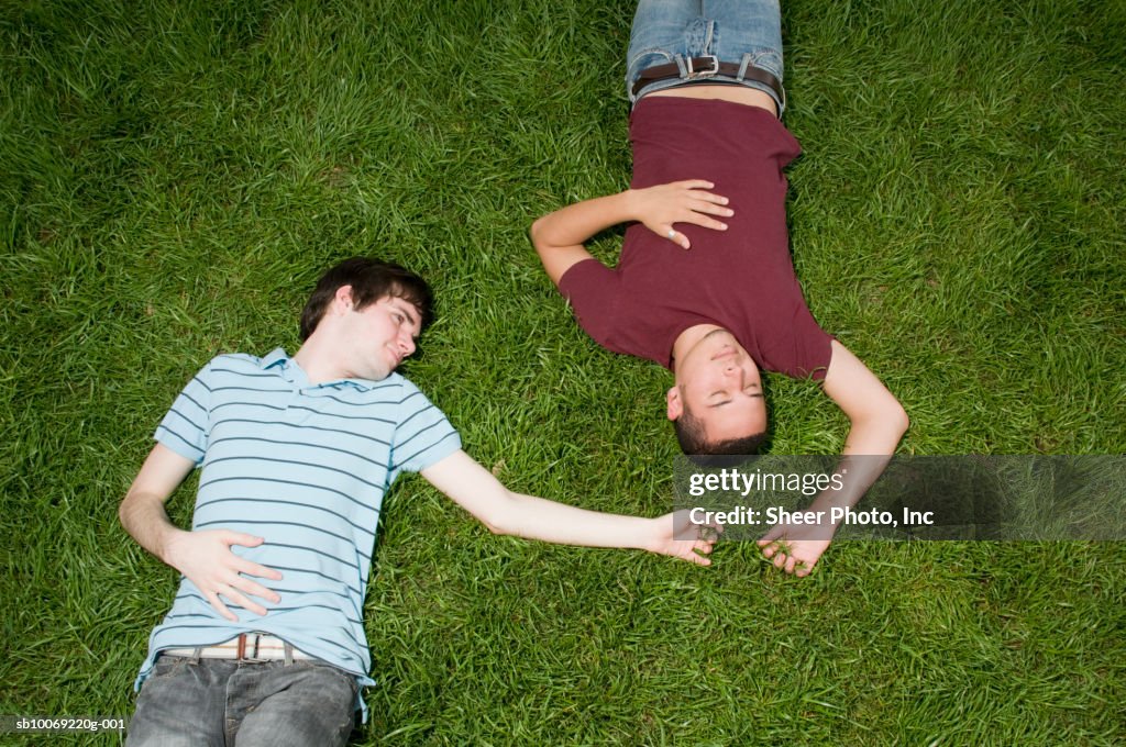 Two young men lying in grass, high angle view