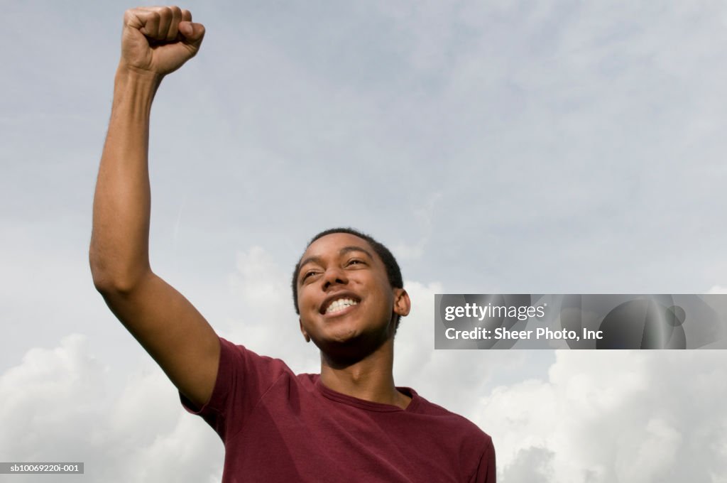 Young man punching air and smiling