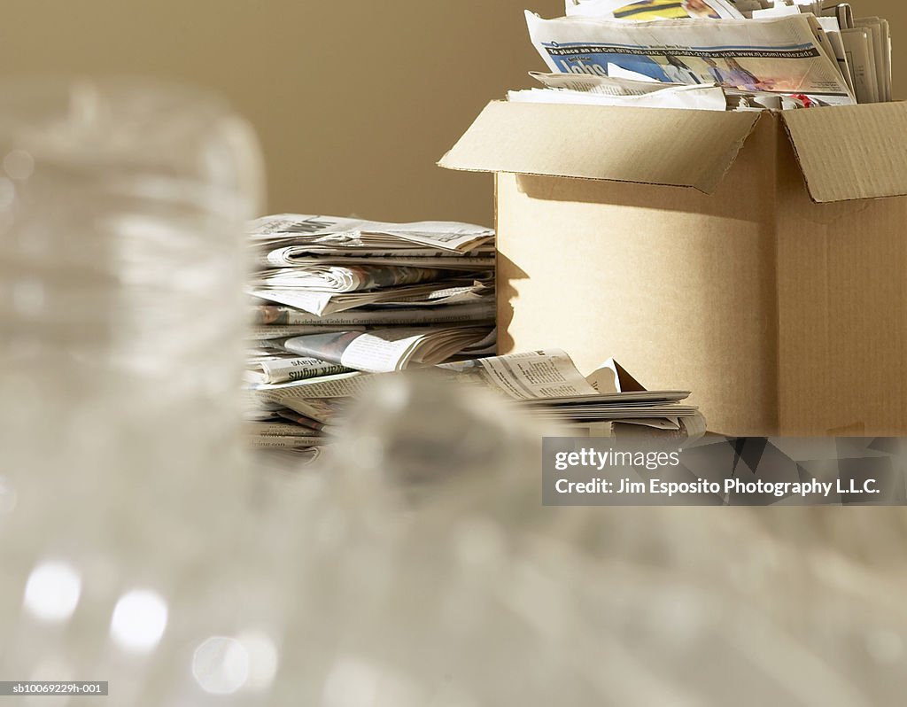 Empty plastic bottles and box of newspapers for recycling