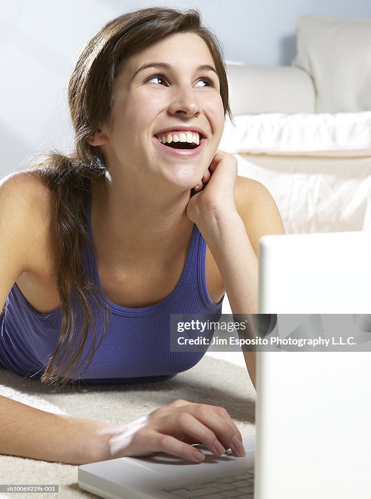 Teenage girl (16-17) using laptop, portrait