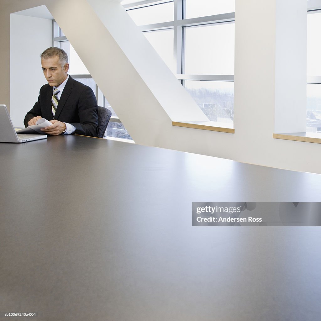 Business man using laptop in conference room