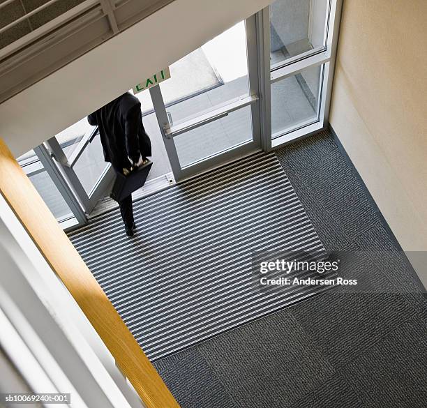 businessman leaving office, low section, high angle view - welcome mat stock pictures, royalty-free photos & images