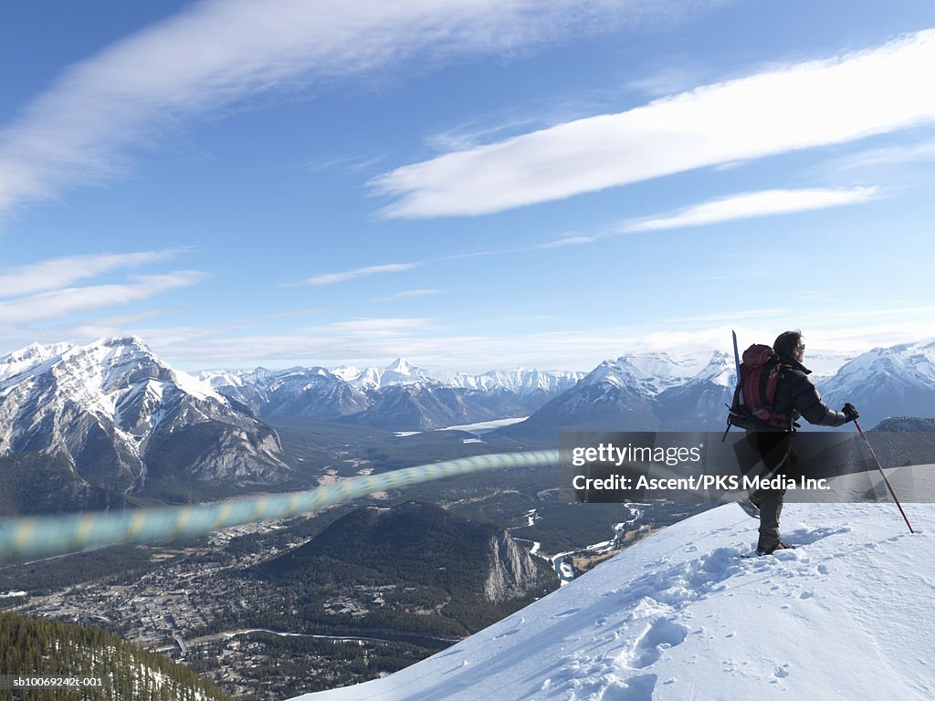 Man snowshoeing on mountain top, rear view