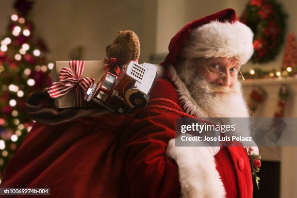 santa claus carrying sack of gifts, portrait, close-up - kris kringle stock pictures, royalty-free photos & images