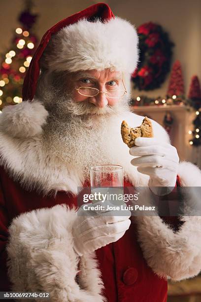 santa claus holding biscuit and glass of milk, portrait, close-up - santa close up stock-fotos und bilder