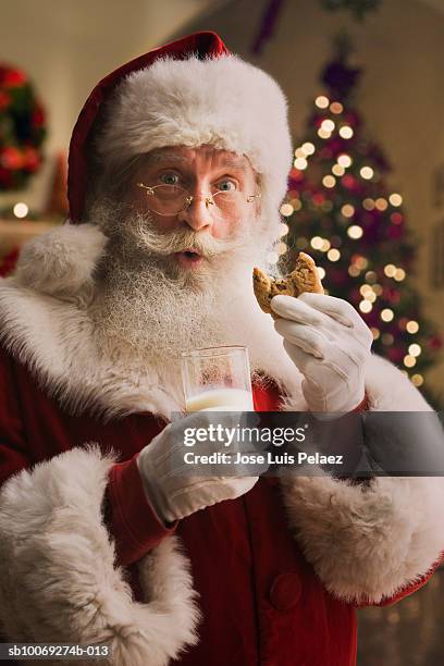 santa claus holding biscuit and glass of milk, portrait, close-up - santa close up stock-fotos und bilder