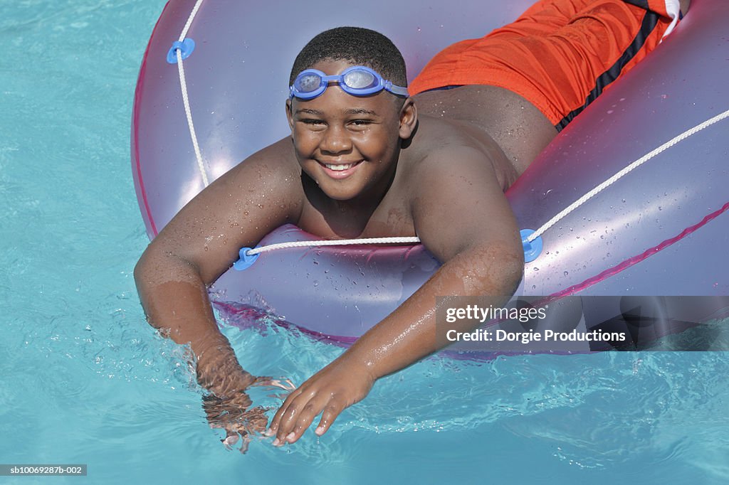 Boy Floating On Inflatable Ring In Pool Smiling Portrait High-Res Stock ...