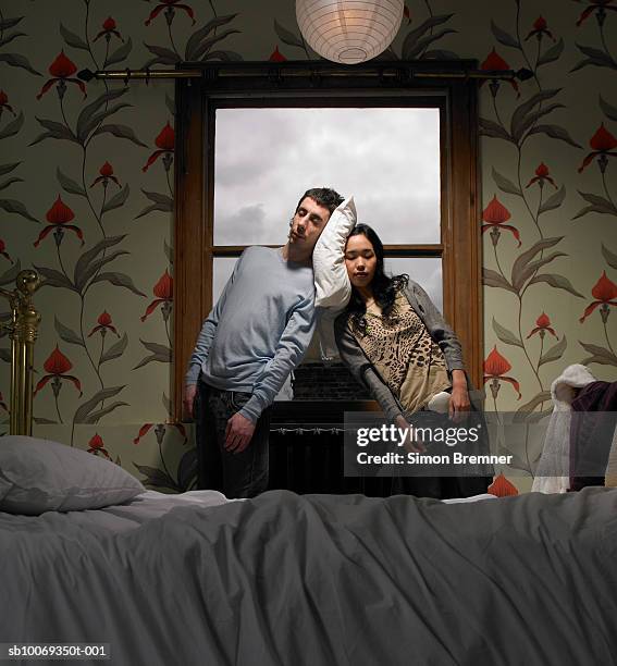 couple resting heads on pillow behind bed - tired couple stock pictures, royalty-free photos & images