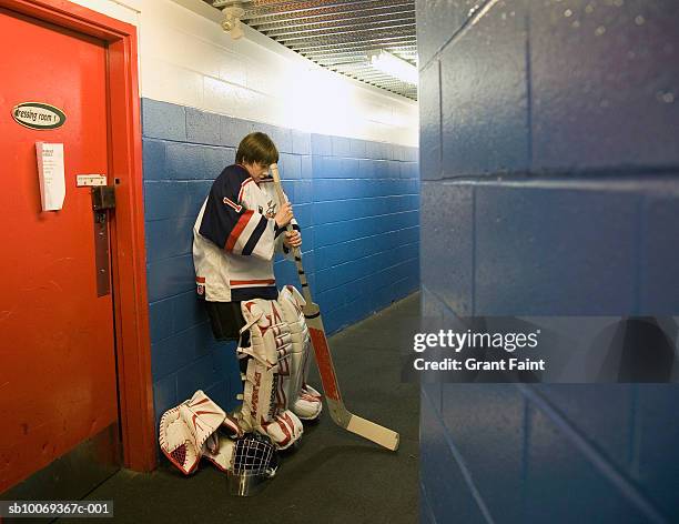 hockey goalie (14-15) in locker room hallway - young boys changing in locker room 個照片及圖片檔