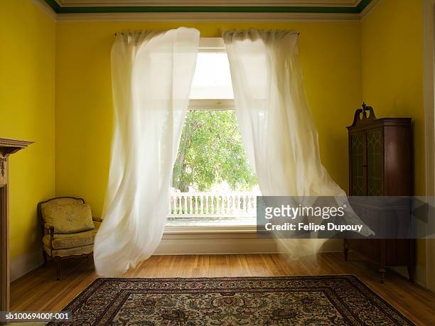 room with curtains billowing at open window - raam stockfoto's en -beelden