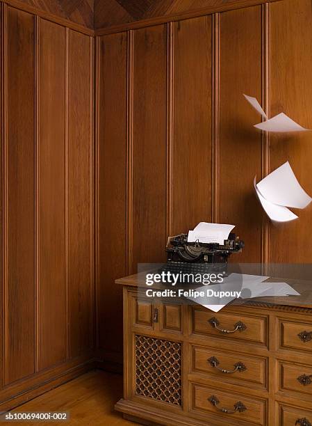 vintage typewriter in wood-paneled room with papers flying - paper blowing stock pictures, royalty-free photos & images