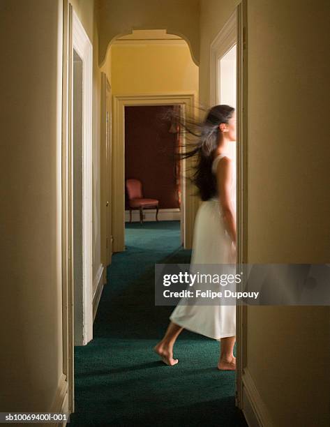woman in white dress walking through doorway - woman entering home stock-fotos und bilder