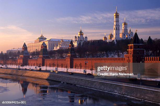 russia, moscow, church of archangel michael and assumption cathedral behind kremlin wall at sunrise - kremlin stock-fotos und bilder