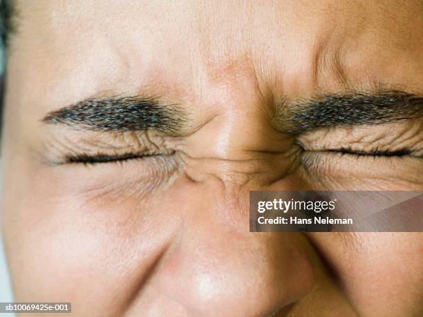 young woman blinking, close-up - augen zukneifen stock-fotos und bilder