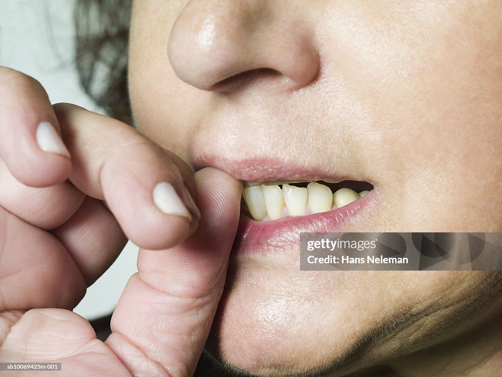 Woman biting nails, close-up