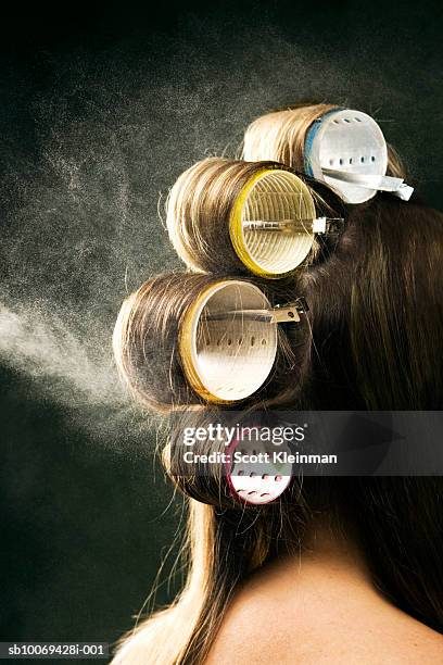 hairspray being sprayed on woman's hair on curlers - hair curlers stockfoto's en -beelden