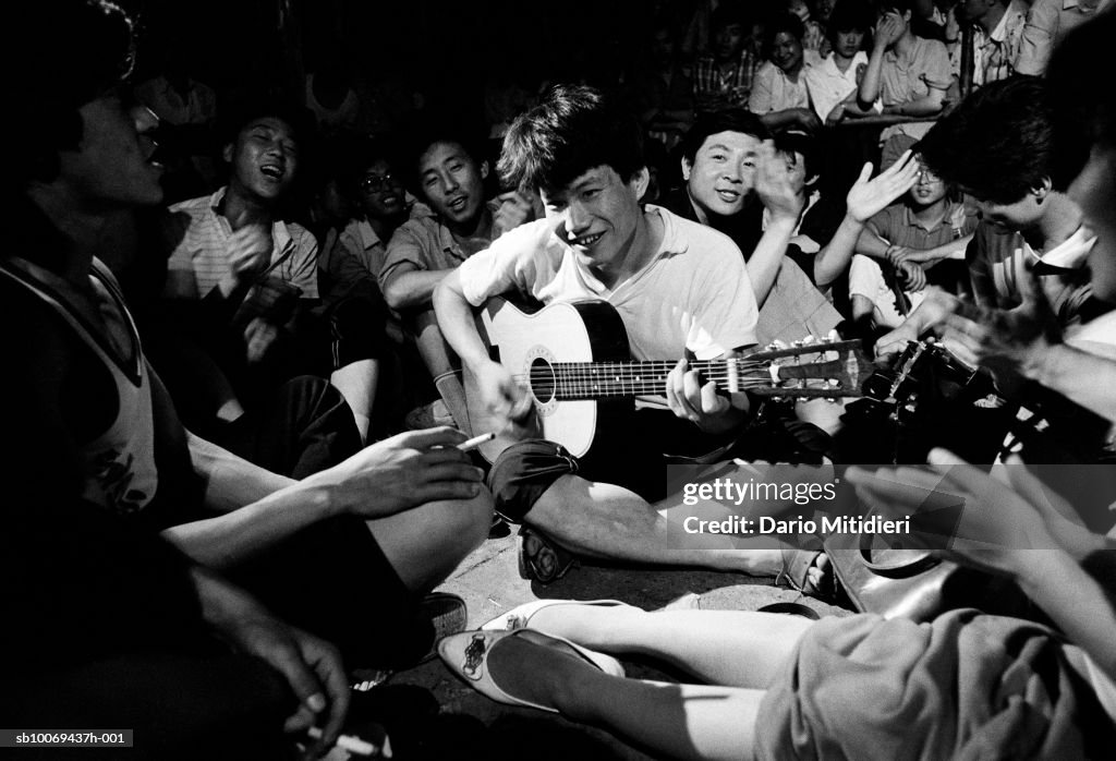 Young man playing guitar during demonstration at Tiananmen Square (B&W)