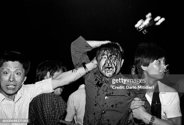 Beijing, China, A wounded soldier of the Chinese army is rescued by students after his tank was destroyed during the Tiananmen Square massacre during...