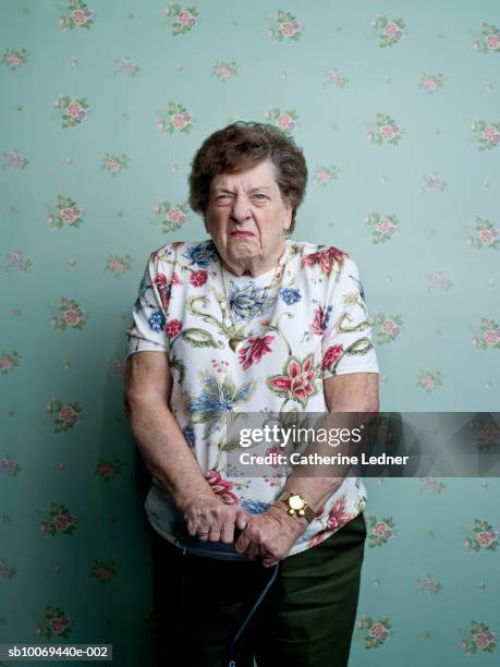 portrait of senior woman frowning - vrouw behangen stockfoto's en -beelden