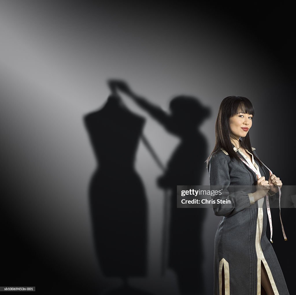 Studio portrait of female fashion designer with shadow behind