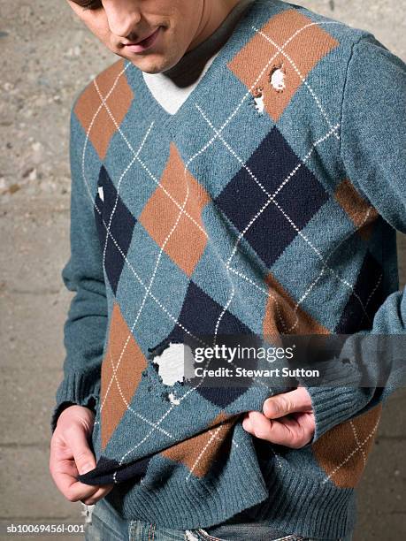 man wearing sweater with holes, outdoors - papillon de nuit photos et images de collection