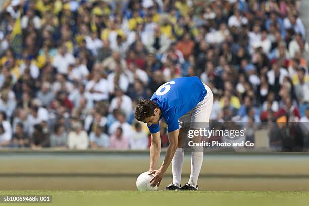 male soccer player placing ball in stadium - positioned stock pictures, royalty-free photos & images