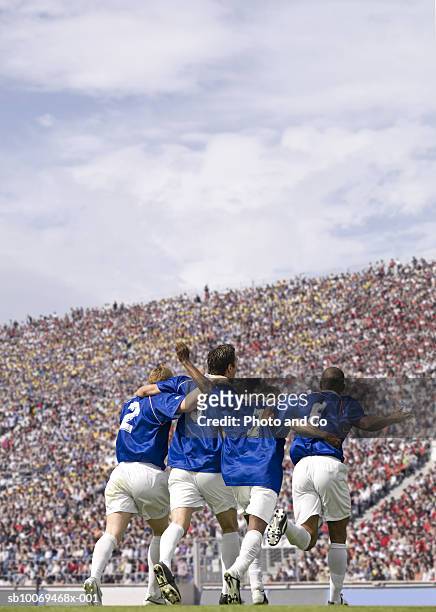 four male soccer players celebrating in stadium, rear view - french football fotografías e imágenes de stock