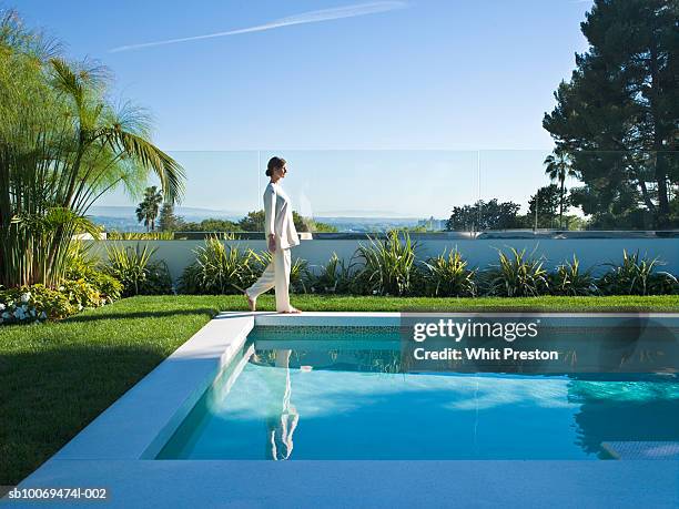 woman walking around  swimming pool, side view - piscine photos et images de collection