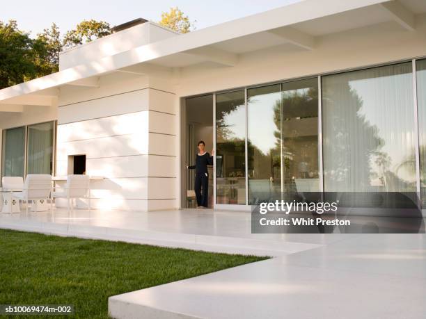 woman standing in doorway - door foto e immagini stock
