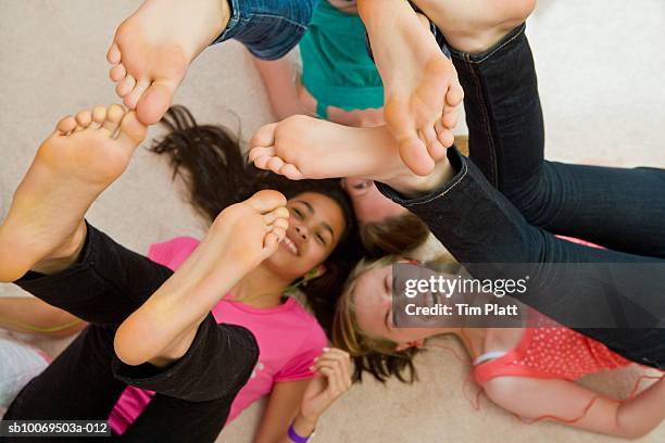 girls (12-13) lying on floor with feet in air - barefoot feet up lying down girl stockfoto's en -beelden