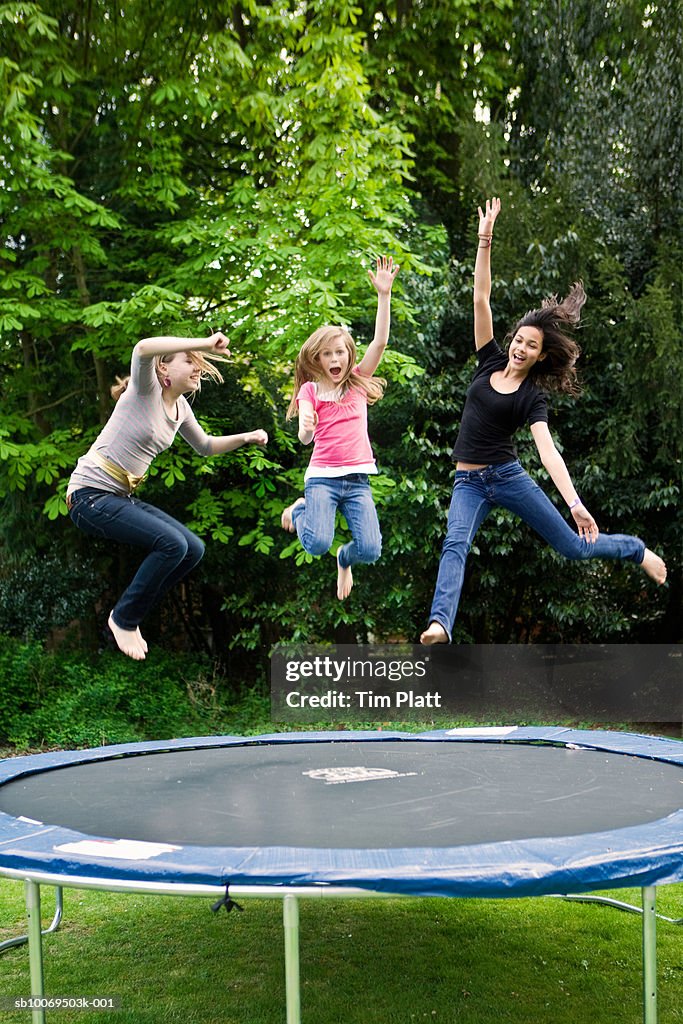 Girls (12-13) jumping on trampoline